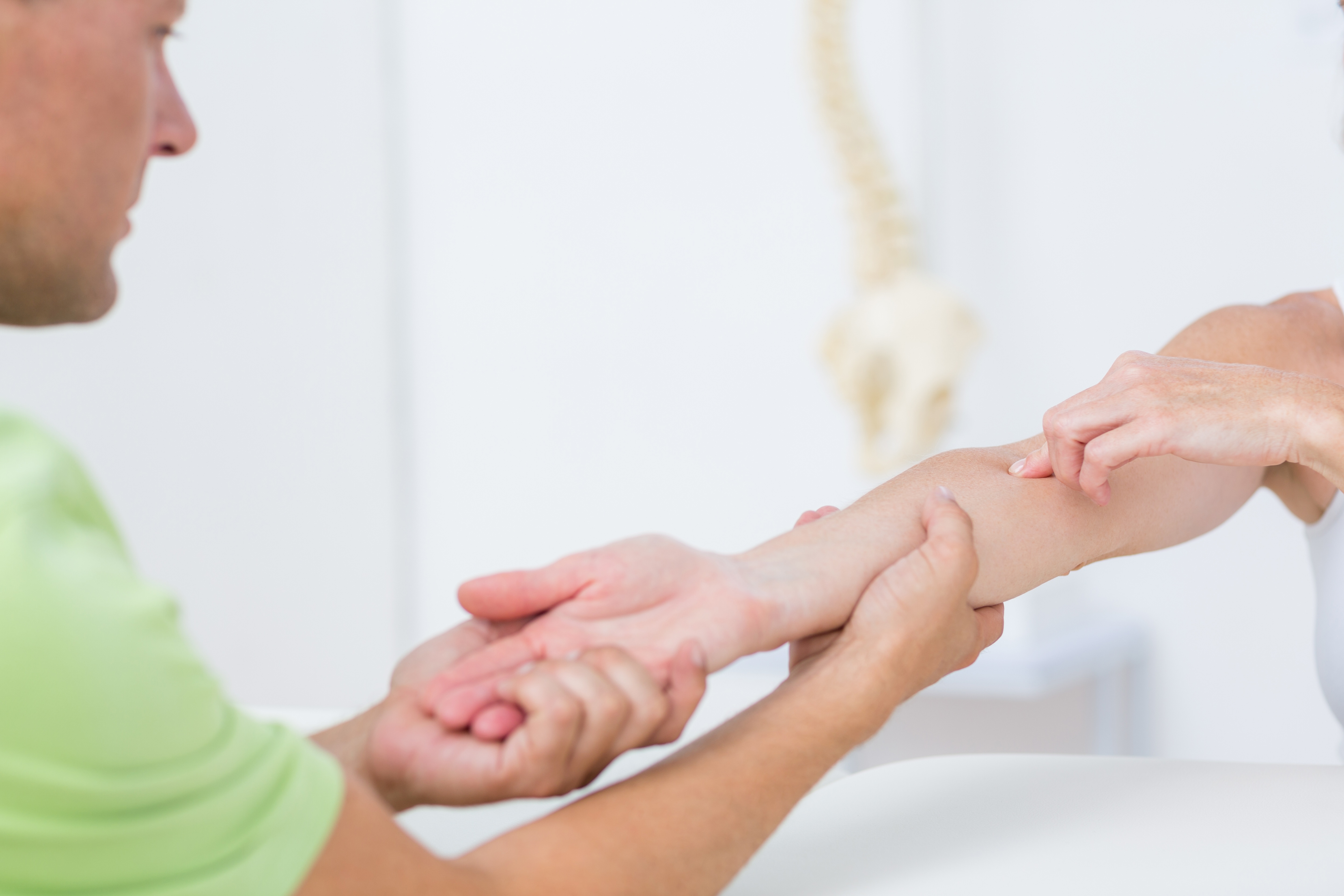 Physical therapist examining cause of pain in elbow